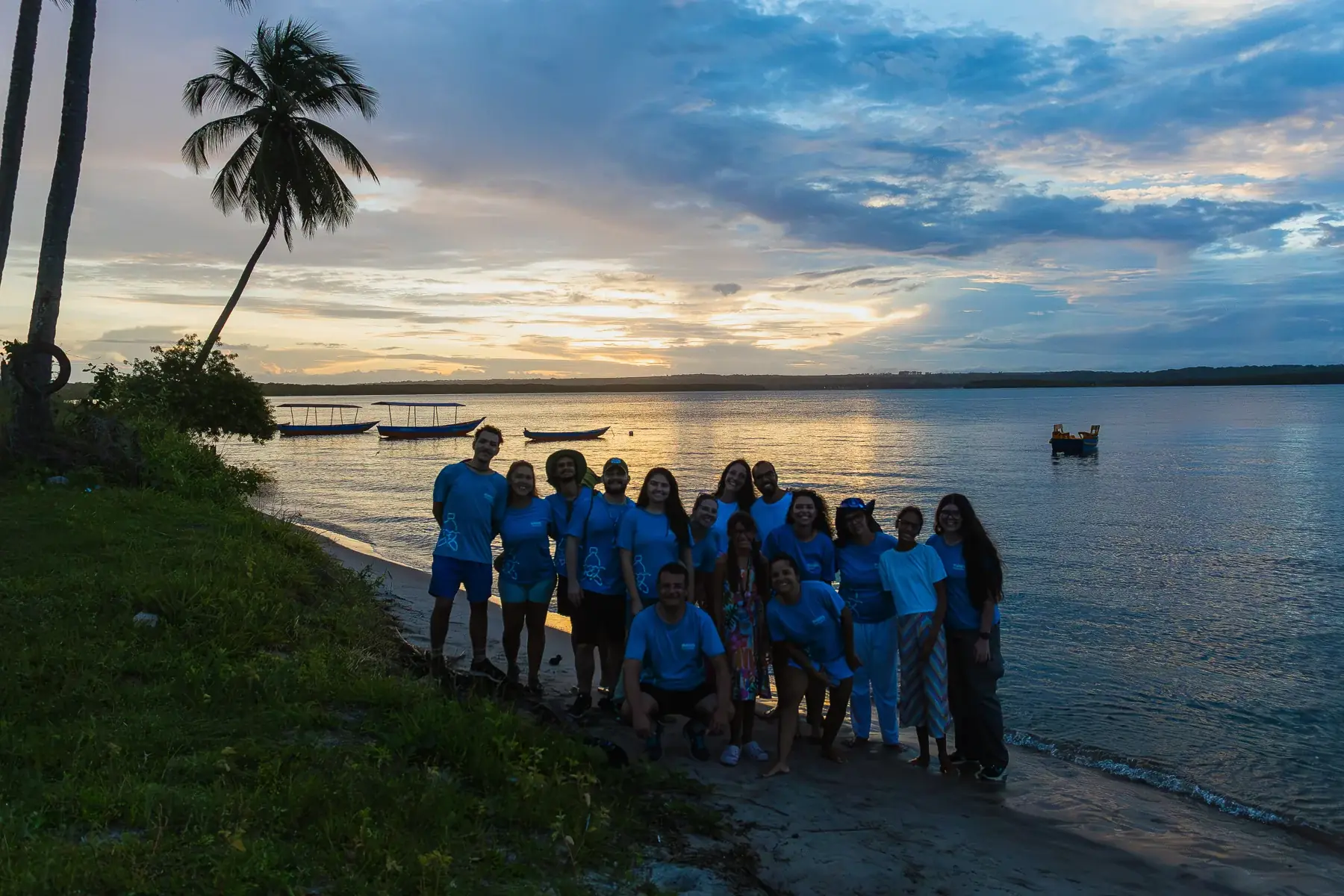 Equipe do projeto à beira da água ao pôr do sol
